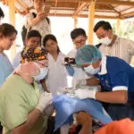A group of people in scrubs and masks gathered around.