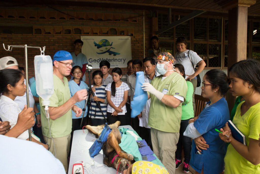 A group of people standing around an operating table.