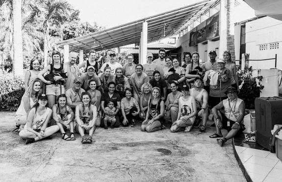 A group of people sitting and standing in front of a building.