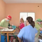 A group of people in scrubs and hats.