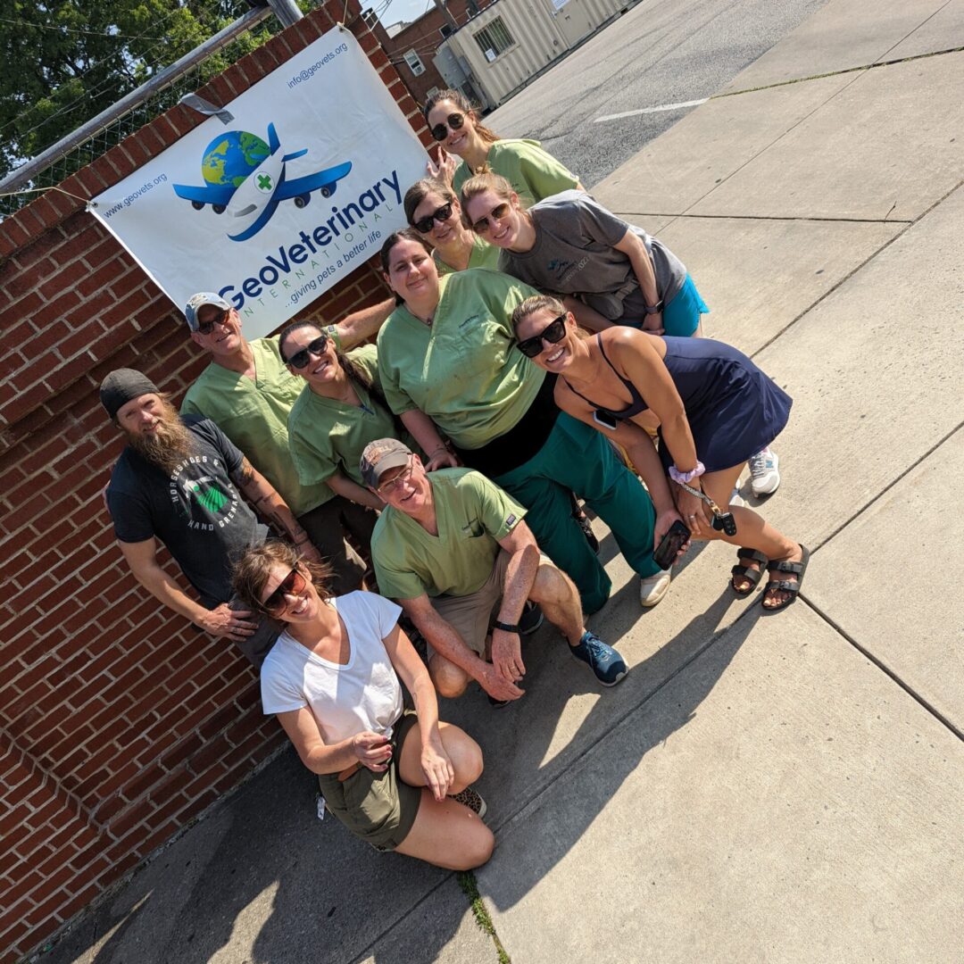 A group of people posing for the camera on the sidewalk.