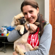 A woman holding a dog in her arms.